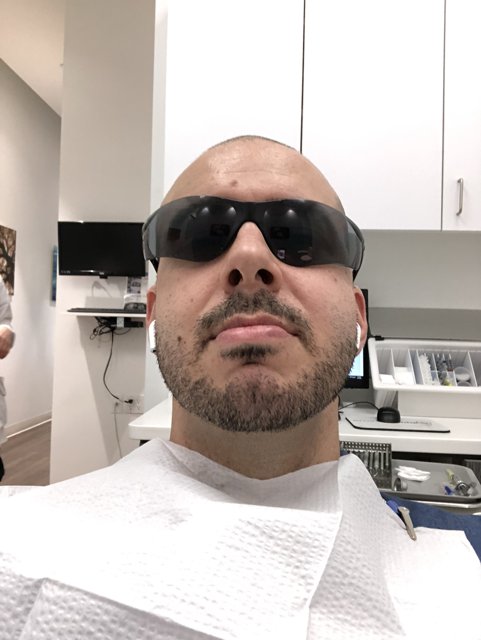 Man with Sunglasses Waiting in Dental Office
