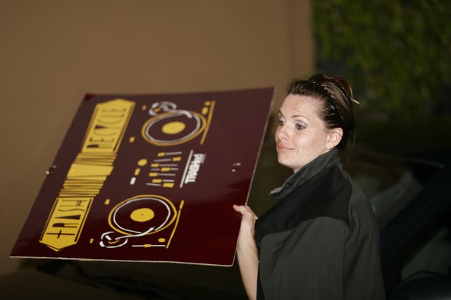 Woman Carries DJ Equipment Promotional Poster Outdoors