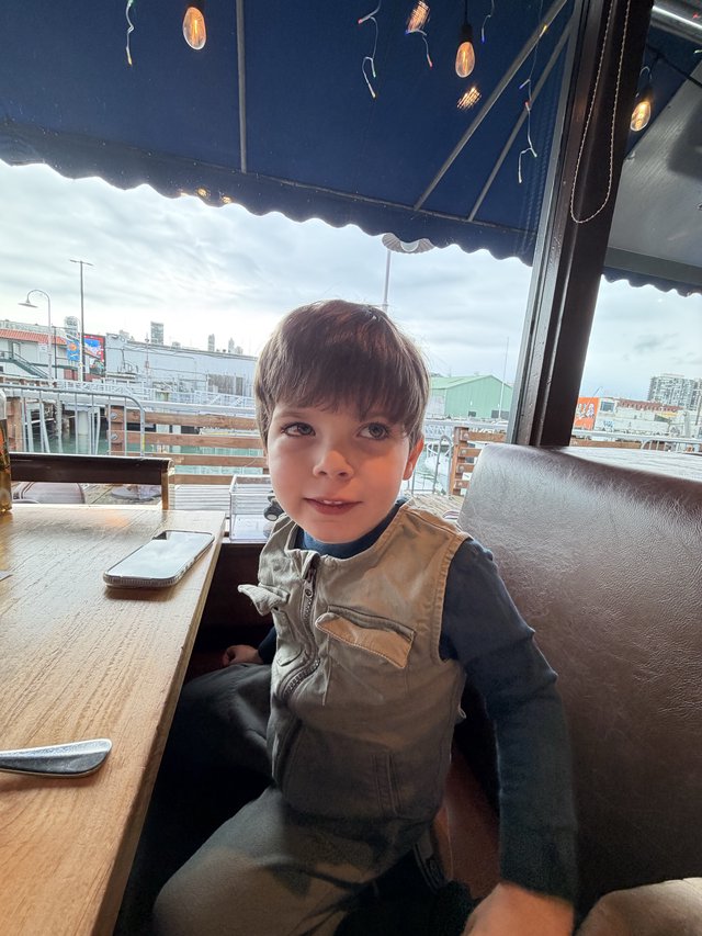 Young Boy at Rooftop Cafe on Overcast Day