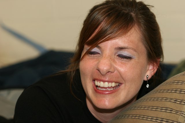 Joyful Woman Laughing Candidly at Indoor Gathering