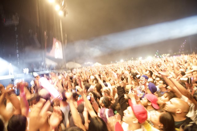 Coachella Crowd Goes Wild Caption: Liu Chunhong and Mick Thomson perform as the audience at Coachella 2012 raises their hands in excitement. The energy and excitement of the concert is palpable as the crowd merges together in one voice.