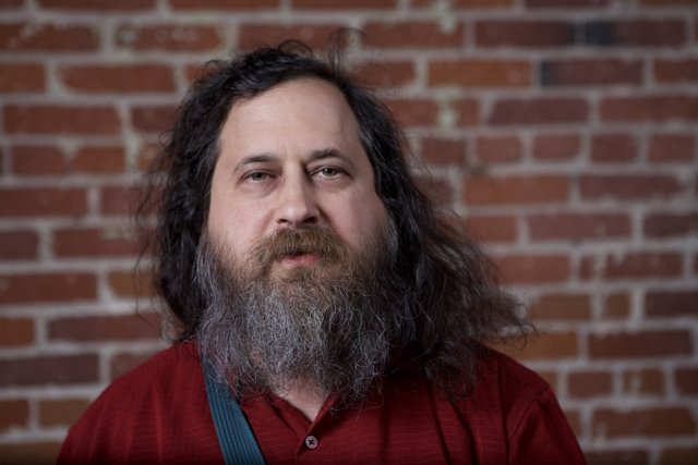 Richard Stallman posing in front of a brick wall