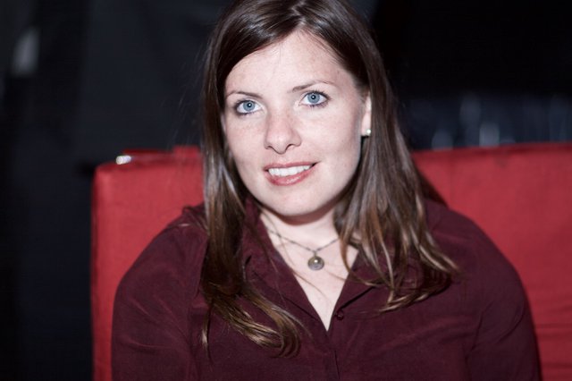 Smiling Woman with Blue Eyes in Red Chair