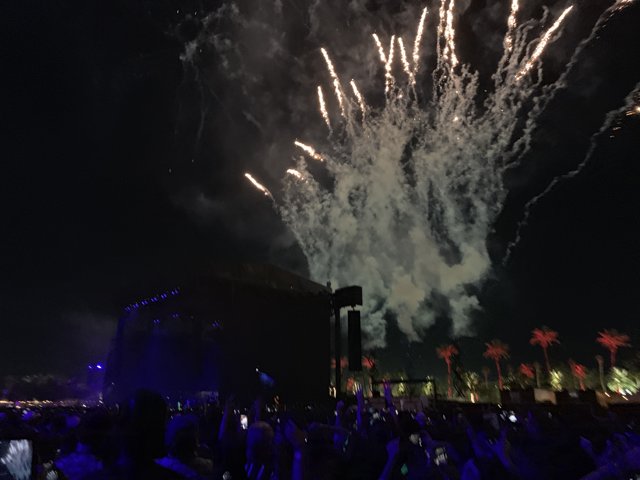 Fireworks Light Up the Night Sky Above a Concert Crowd