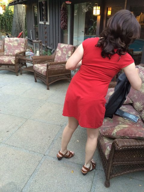 Woman in Red Dress Relaxing on Patio Couch