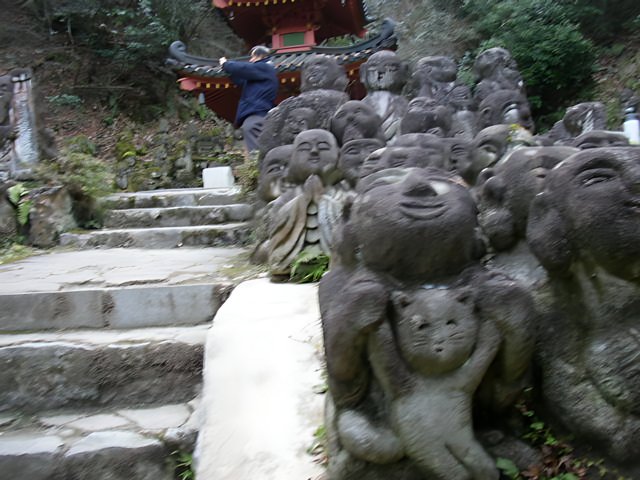 Man Standing Amongst Statues at Temple