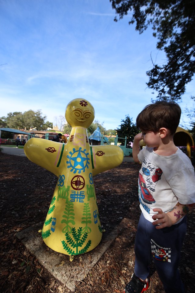 Young Boy Admiring Yellow Decorative Doll at Fantasyland