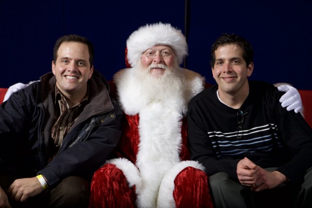 Three Men Strike a Pose with Santa Claus