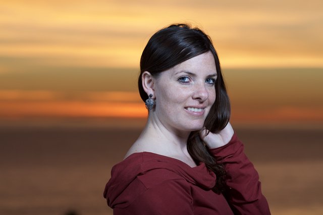 Dark-Haired Woman Smiling at Sunset by Sea