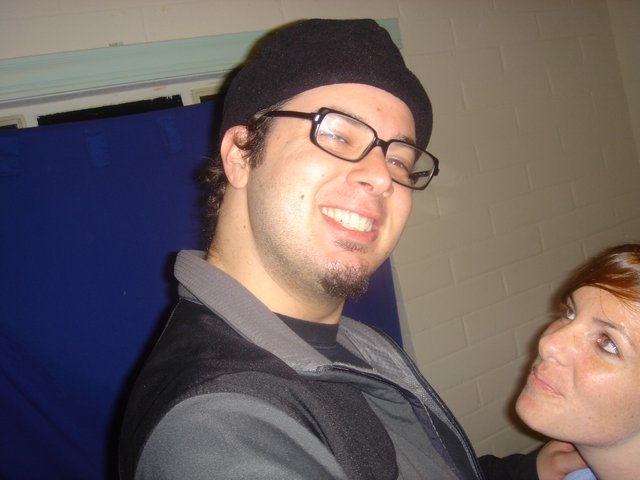 Smiling Man in Black Beanie at Indoor Gathering