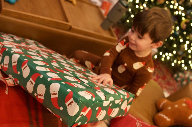 Christmas Morning Joy: Child Opening Festive Present
