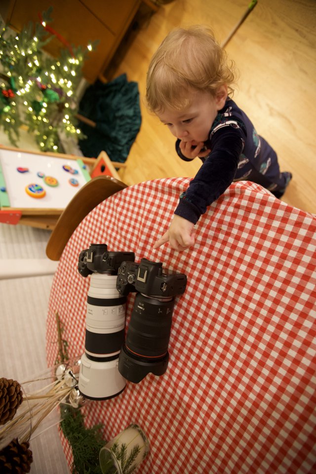 Young Child Exploring Professional Camera Equipment at Christmas
