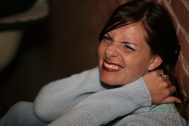 Joyful Woman Laughing Against Brick Wall
