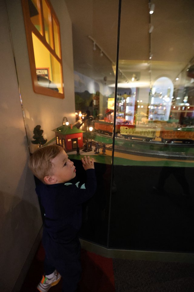 Young Boy Examining Model Train Display at Museum