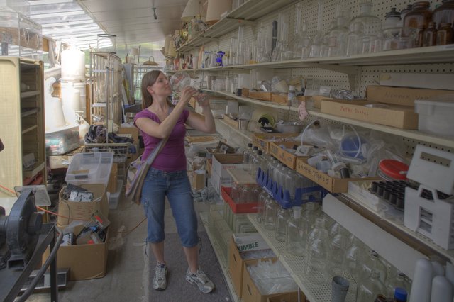 Penelope Examines Glassware at Black Hole Surplus Store