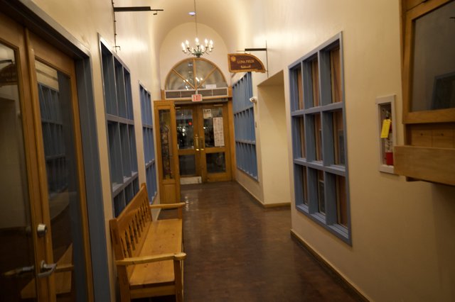 Historic School Hallway with Blue Lockers and Wooden Bench