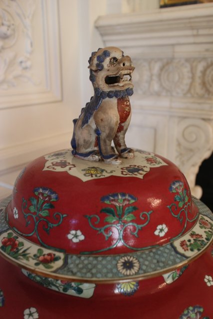 Ceramic Dog Figurine on Red and White Pottery Dish