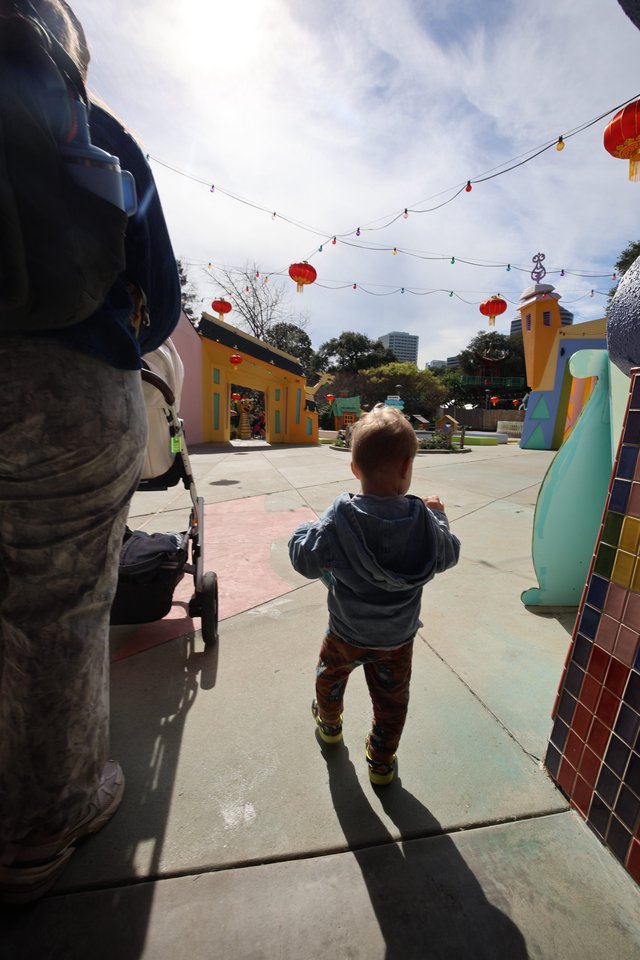 Young Child Exploring Colorful Plaza with Red Lanterns
