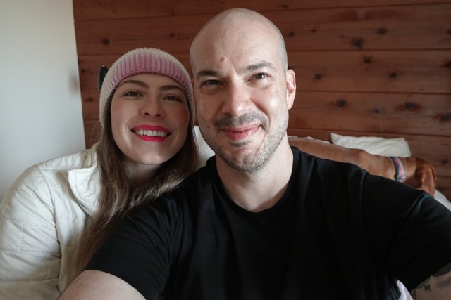 Happy Couple Takes Selfie in front of Wall