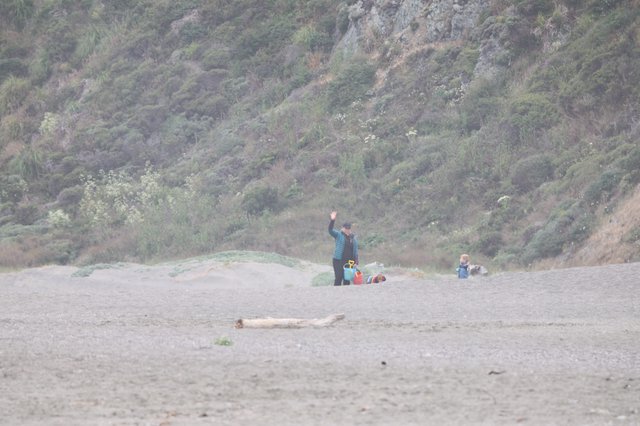 Family Waving on a Misty Gravel Beach