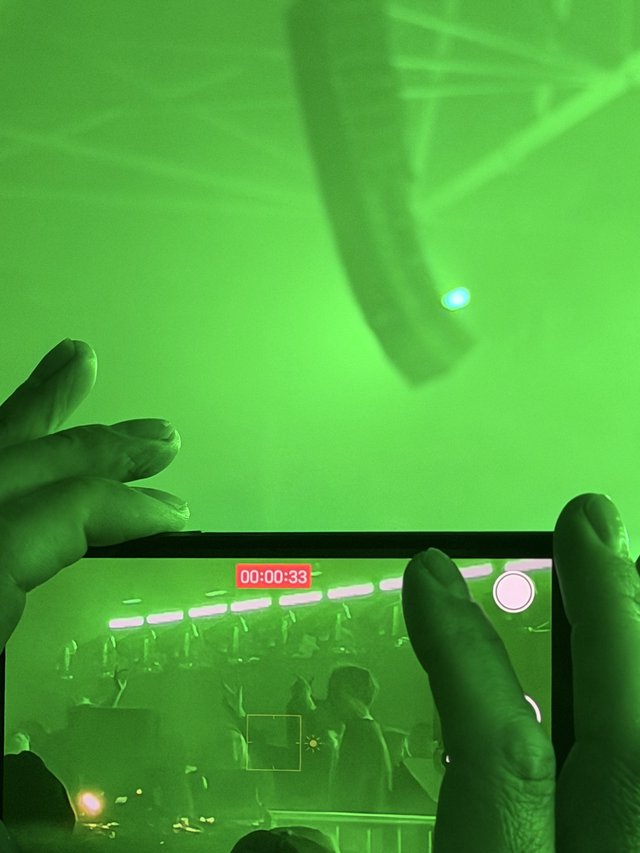 Recording a Concert Through Phone Screen in Green Stage Lighting