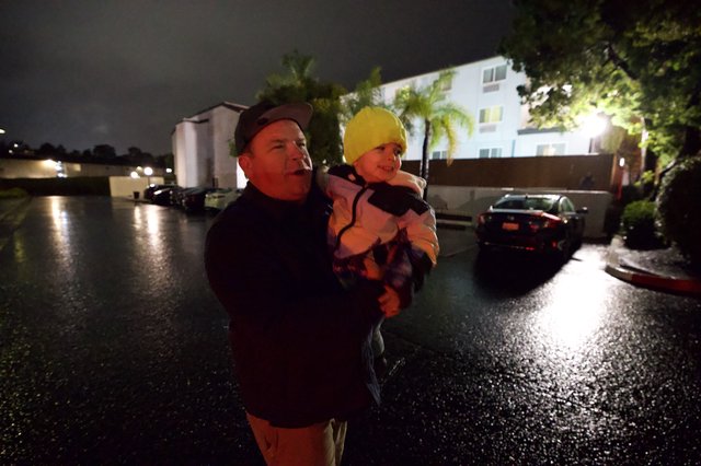 Father and Child During Nighttime Flood Emergency Evacuation