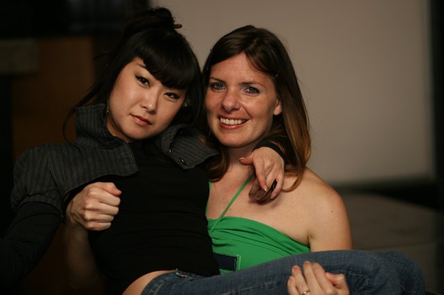 Two Friends Posing Together at Indoor Gathering