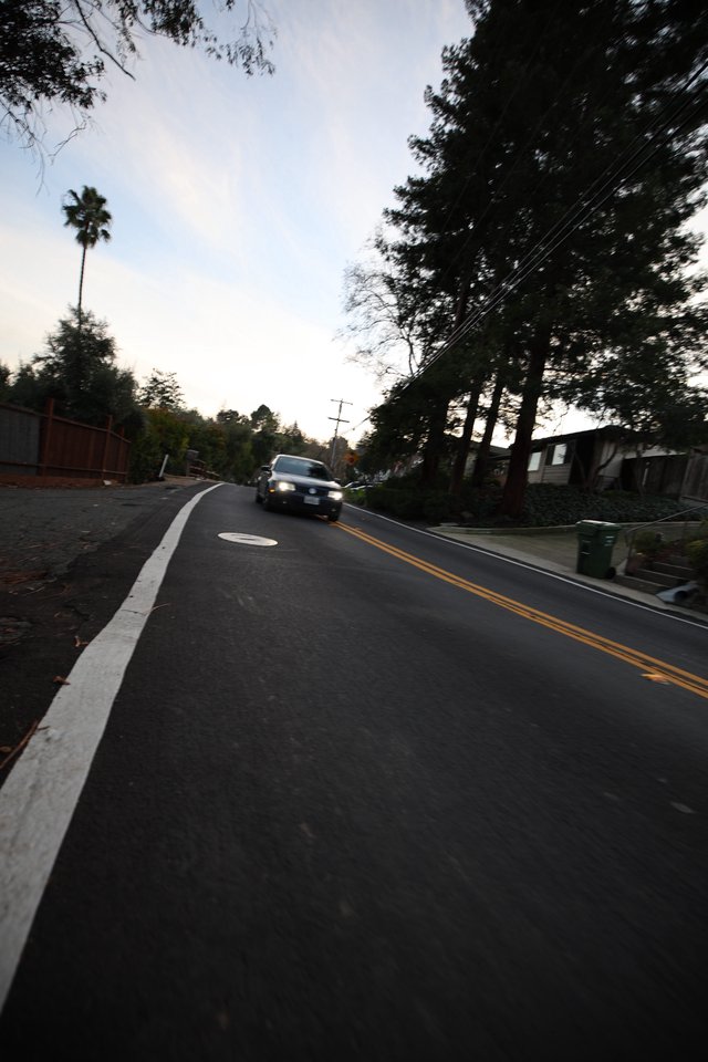 Residential Street at Dusk with Approaching Vehicle