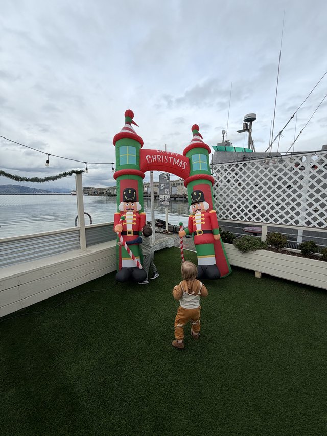 Children Exploring Inflatable Christmas Display by the Waterfront