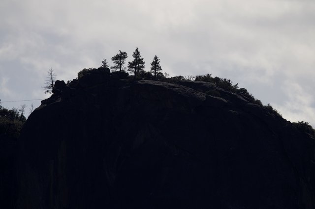 Silhouetted Rocky Summit Against Overcast Winter Sky