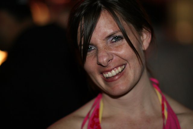 Radiant Smile of a Woman at a Nighttime Gathering