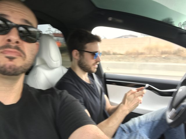 Two Men Multi-tasking while Driving