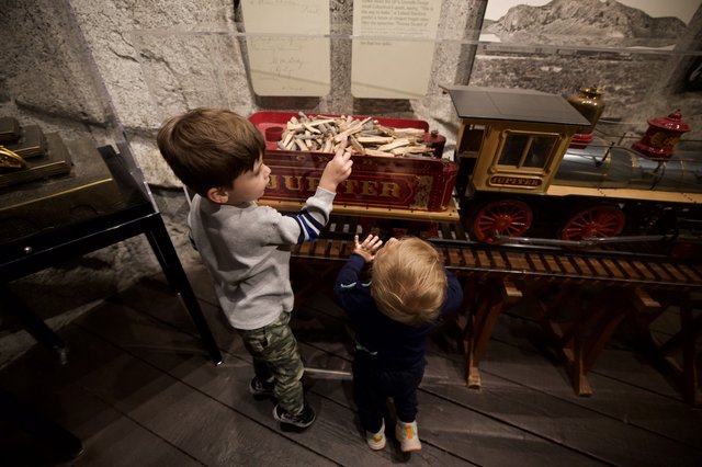 Children Exploring Historic Train Exhibit at Museum