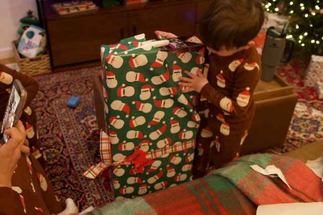 Child Opening Large Christmas Gift on Holiday Morning
