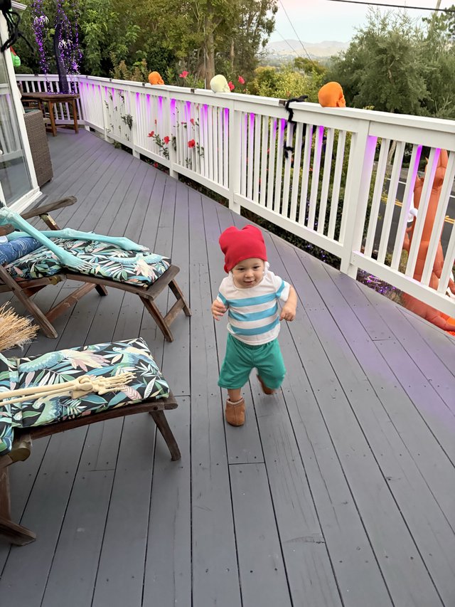 Joyful Toddler Running on Decorated Deck