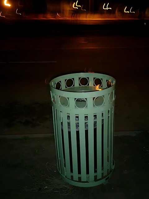 Tin Trash Can on Night Sidewalk