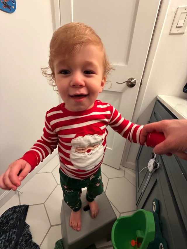 Toddler in Festive Christmas Pajamas in Bathroom