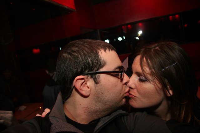 Couple Sharing a Kiss at Dimly Lit Nightclub
