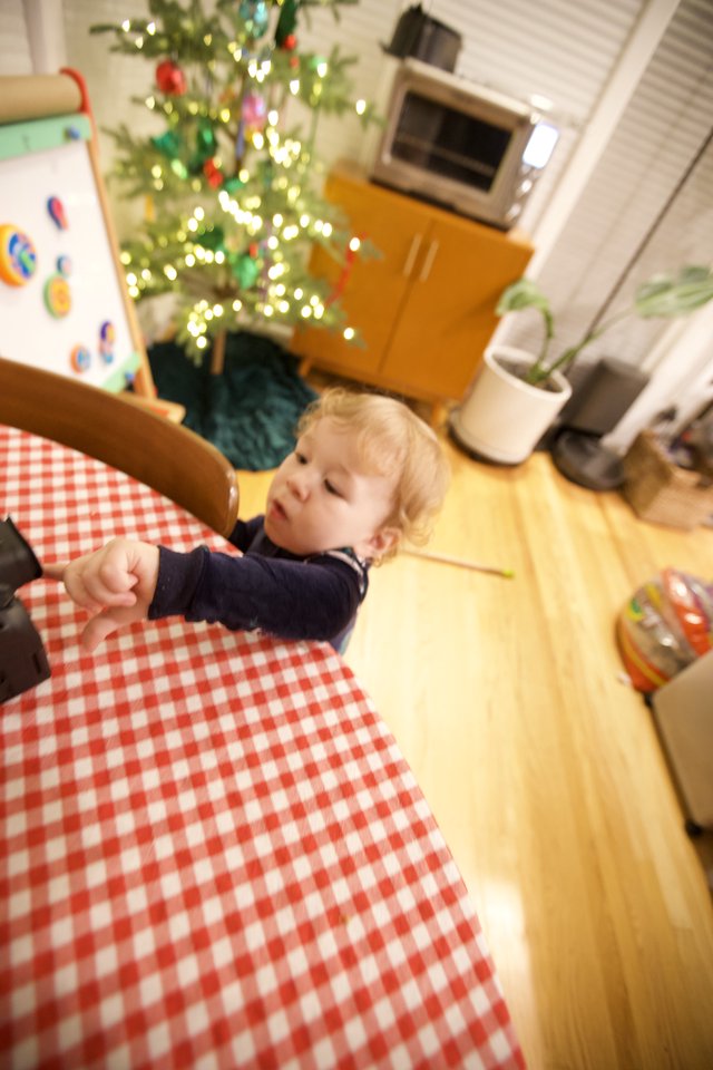 Toddler Helping Set Christmas Table in Kitchen