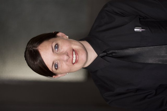 Professional Portrait of Smiling Woman in Black Uniform