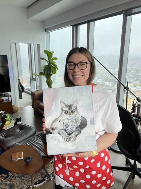 Woman Holds Beautiful Painting of a Cat in Living Room