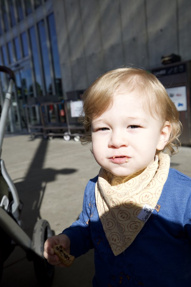 Toddler with Blonde Hair Enjoying Snack Outdoors