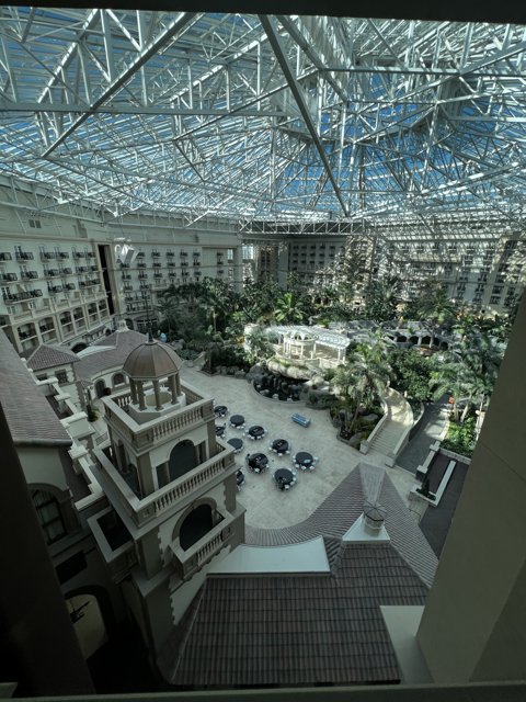 City Oasis Caption: The stunning atrium of the Westin St. Louis provides a refreshing escape from the bustling metropolis outside, with two towering office buildings framing the view. The skylight overhead illuminates a lush garden oasis with a swimming pool, potted plants, and elegant furnishings. A perfect spot for relaxation and rejuvenation in the heart of the city.