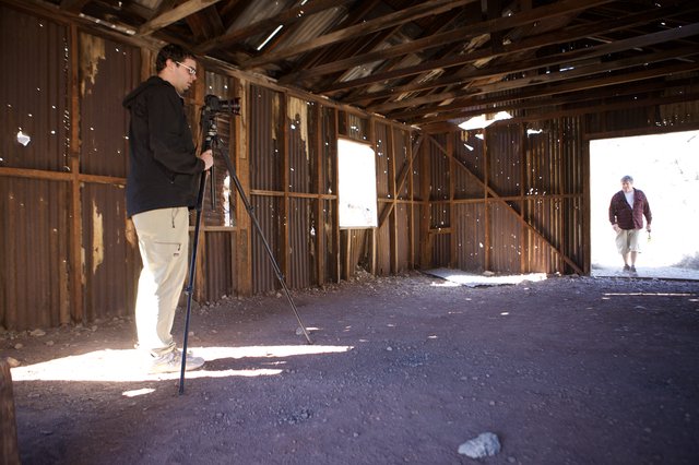 Photographer Documenting Abandoned Desert Structure Interior