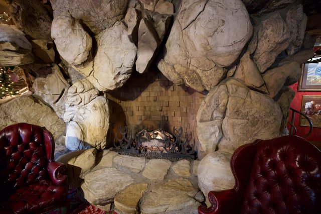 Rustic Stone Fireplace with Leather Armchairs in Cave-Like Interior