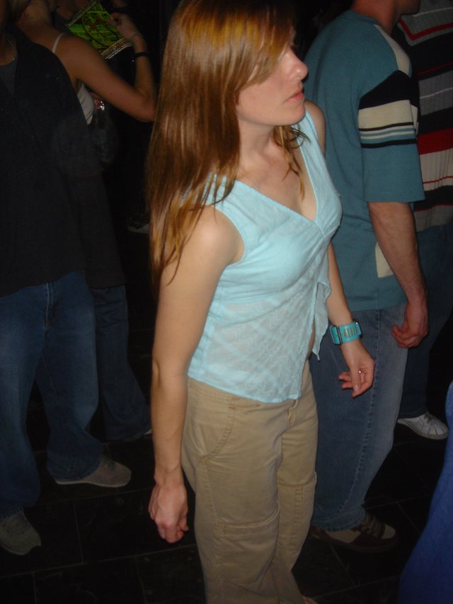 Young Woman Dancing at Dimly Lit Nightclub