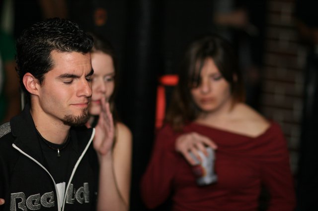 Young Man Lost in Thought at Nightclub Party