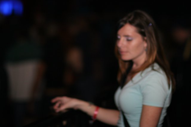 Woman in White Tee at Dimly Lit Nightclub