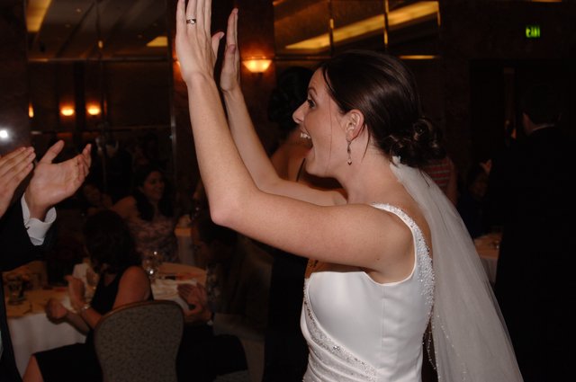Joyful Bride High-Fives Guest at Wedding Reception