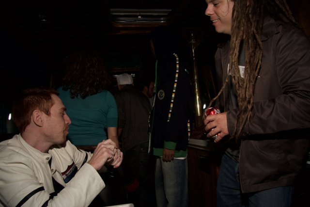 Man with Dreadlocks Enjoying Drinks with Friends at the Pub